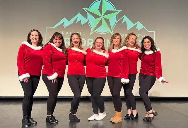 women on a stage in matching costumes